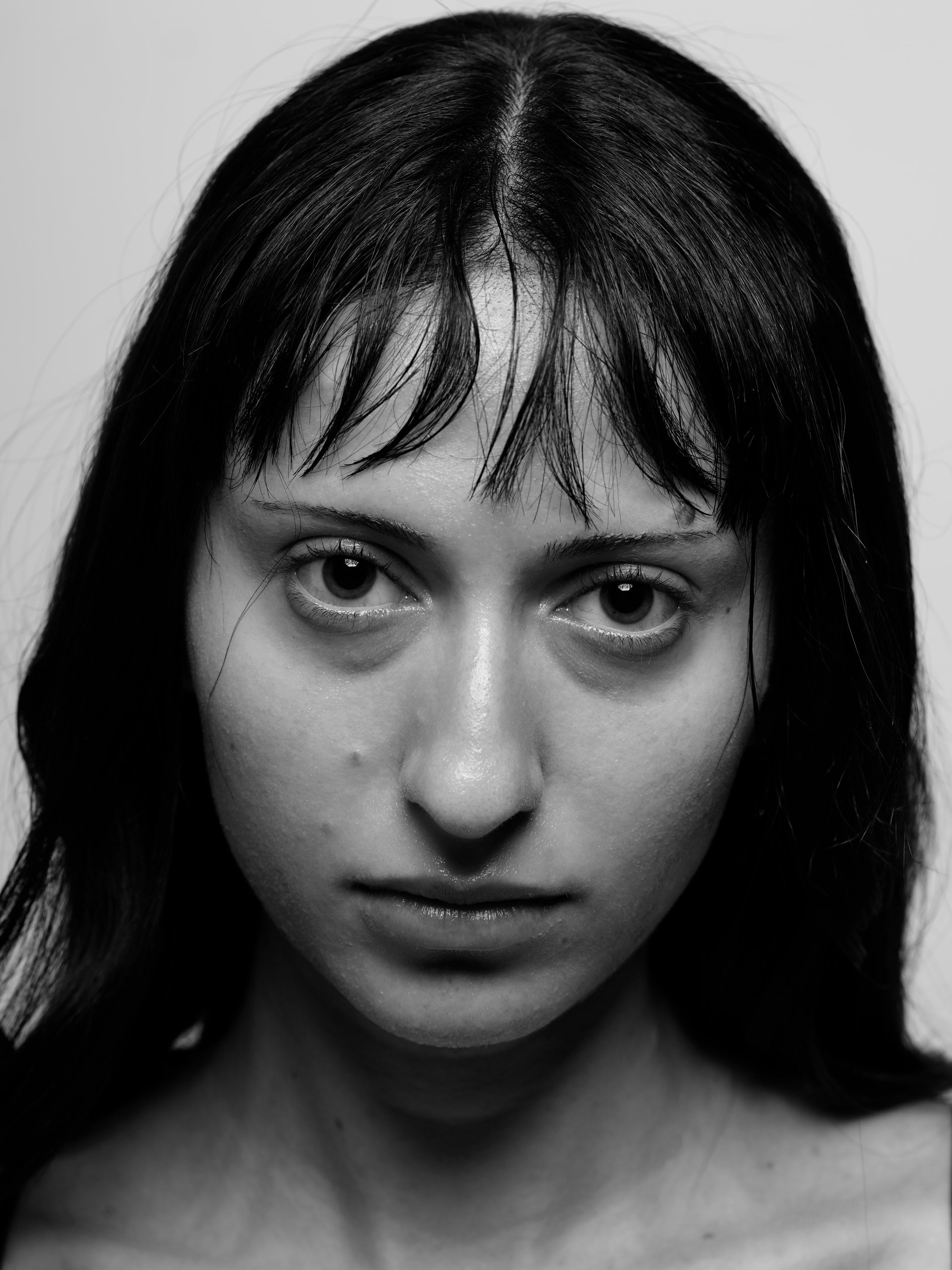 Head-on close-up of Chrissa with a fringe and long dark hair, looking straight at the camera.
